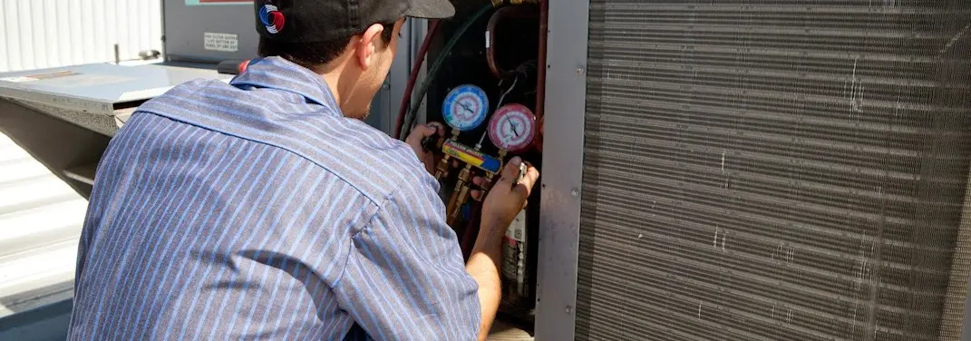 HVAC technician servicing a condenser unit in Petal